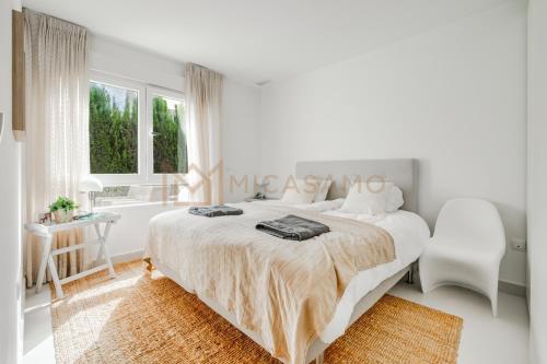 a white bedroom with a large bed and a desk at Four Bedroom Mimosas Villa With A Private Pool in Atamaría