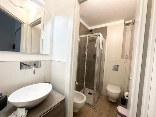 uma casa de banho branca com um lavatório e um chuveiro em Small house near the Station em Milão