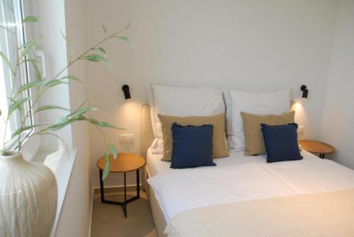 a bedroom with a bed with blue pillows and a vase at Vodice For You - Holiday Homes in Vodice