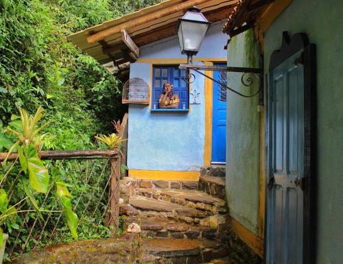 a woman looking out the window of a house at Pousada Lua Bonita in Nova Lima