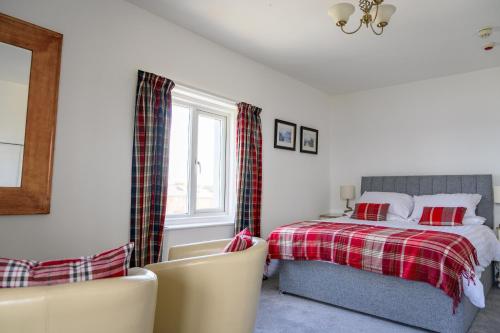 ein Schlafzimmer mit einem Bett und zwei Stühlen darin in der Unterkunft The Sandbeck, Commondale in Whitby