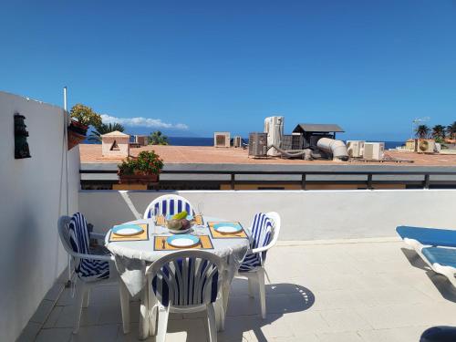 a table and chairs on a balcony with a view of the ocean at Arena Sol by HelloApartments in Puerto de Santiago