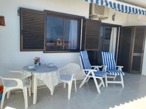 a patio with a table and chairs and a window at Arena Sol by HelloApartments in Puerto de Santiago