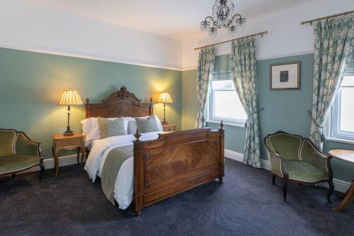 a bedroom with a large bed and two chairs at The French Partridge, in Northampton