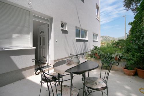une petite table et des chaises assises sur une terrasse dans l'établissement Apartments Parcela, à Seget Vranjica