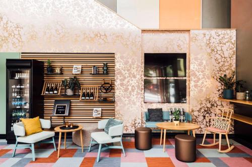 a lobby with tables and chairs and a wall at Vienna House Easy by Wyndham Stuttgart in Stuttgart