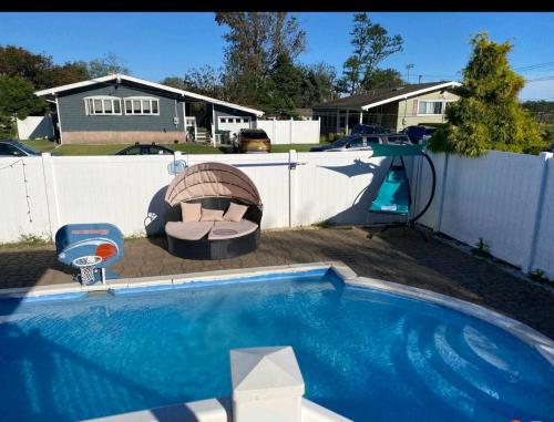 einen Pool im Hinterhof mit einem weißen Zaun und einem Pool in der Unterkunft bassement whit jackuzzi and pool in Copiague