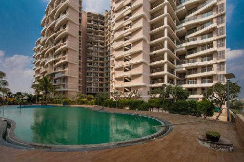 a swimming pool in front of two tall buildings at Staeg Skyline View 3BHK - 1404 in Indore