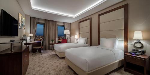 Una habitación de hotel con dos camas y un escritorio. en Doubletree By Hilton Istanbul Topkapi, en Estambul