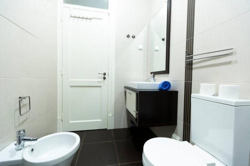 a white bathroom with a toilet and a sink at Ola Lisbon - Campo Pequeno in Lisbon