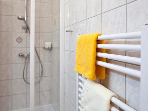 y baño con ducha y toalla amarilla. en Appartement NOVA, en Graz