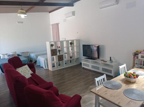 sala de estar con sofá, TV y mesa en Huerta Alegría, en Casariche
