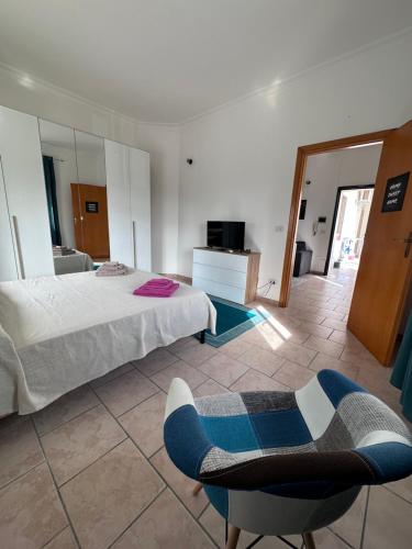 a bedroom with a bed and a chair in it at La Maison de Marianne in Trepuzzi