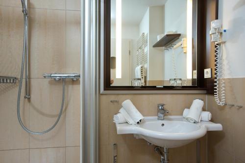 a bathroom with a sink and a shower with a mirror at Hapimag Resort Aalborg in Westerland (Sylt)