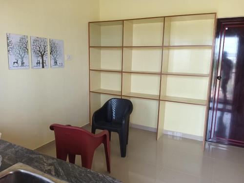 una habitación con una silla azul y estanterías en Serene Super Deluxe Row Villa, en Karumattampatti