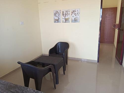 2 sillas y una mesa en una habitación en Serene Super Deluxe Row Villa, en Karumattampatti