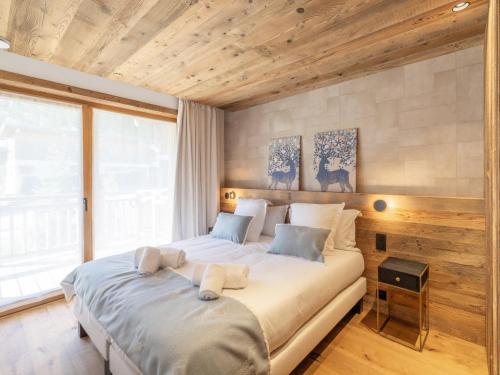 a large bed in a room with a large window at Chalet Courchevel, 6 pièces, 12 personnes - FR-1-568-36 in Courchevel