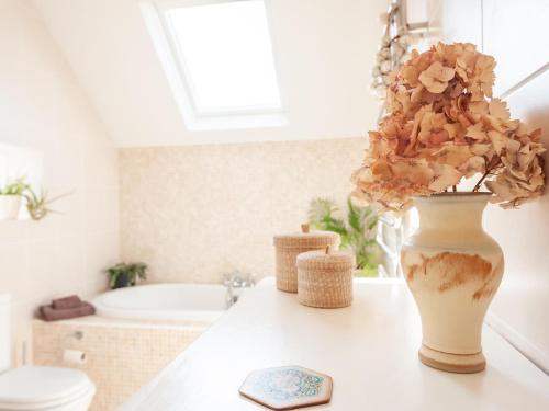 a bathroom with a toilet and a vase with flowers on a counter at Pass the Keys Breathtaking view Family home Leeds in Leeds