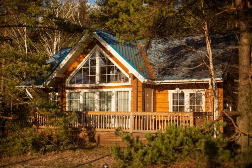 OzerkiにあるSea Home Cottagesのポーチと大きな窓が備わるログホーム