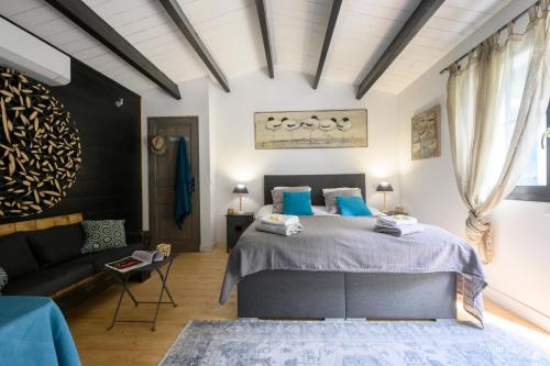 a bedroom with a bed and a couch at La dune du bien etre in La Couarde-sur-Mer