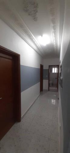 a room with a hallway with blue and white walls at MediSweet Apartments Meublés in Yaoundé