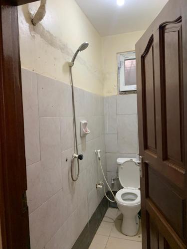 Classic Shanzu 2bedroom apartment في مومباسا: حمام مع مرحاض ومقصورة دش