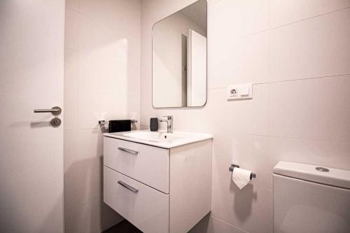 La salle de bains blanche est pourvue d'un lavabo et de toilettes. dans l'établissement El Salvador 53, à Las Palmas de Gran Canaria