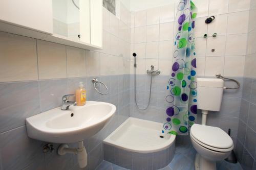BogomoljeにあるRobinson Editaのバスルーム(洗面台、トイレ、シャワーカーテン付)