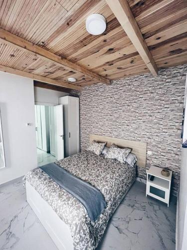 a bedroom with a bed and a brick wall at Apartamento KENOA metropolitano in Madrid