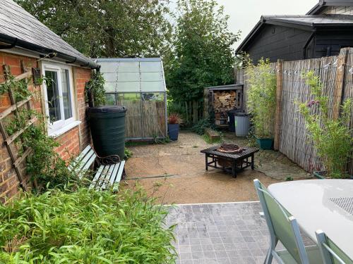 a backyard with a picnic table and a fence at Tiny Cottage for couples in the countryside in Shalfleet