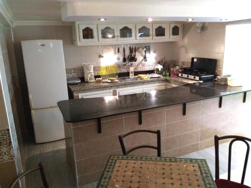 cocina con nevera, mesa y sillas en Shared apartment-Appartement en colocation tout confort centre ville, en Marrakech
