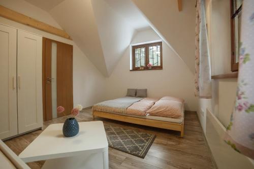 a small bedroom with a bed and a table at Chata Malý Sokol in Smižany