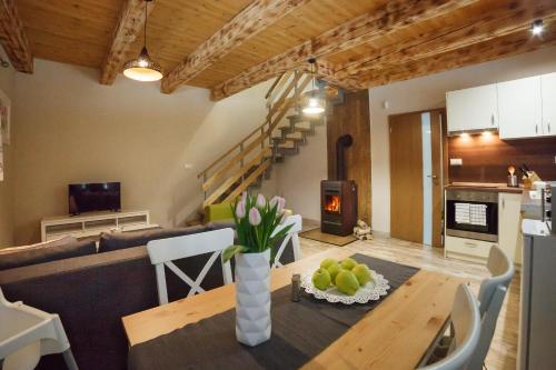 a kitchen and living room with a table and a couch at Chata Malý Sokol in Smižany