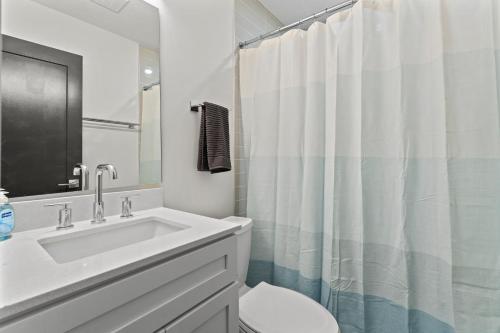 een witte badkamer met een wastafel en een toilet bij West Taylor Run Hotel in Alexandria