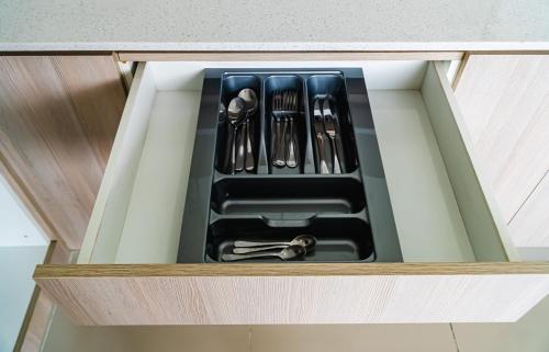 a drawer with utensils in a kitchen cabinet at Chequers Suites Subic Bay in Olongapo