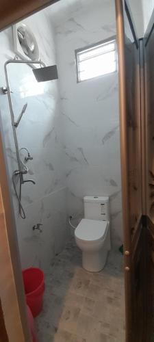 bagno bianco con servizi igienici e finestra di Studio Teratak Alisha Permatang Pauh a Permatang Pauh