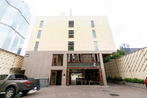 a building with a car parked in front of it at A Room Bangkok Sathorn in Bangkok