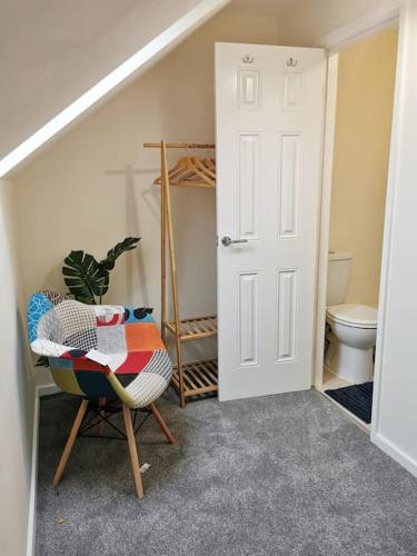 a room with a bathroom with a toilet and a chair at Fivehill 4 Bedrooms Apartments 6 beds 4 Showers Free Parking in Sheffield