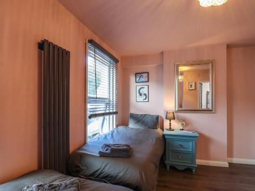 um quarto com uma cama, um espelho e uma janela em Comfortable Margate Home em Margate