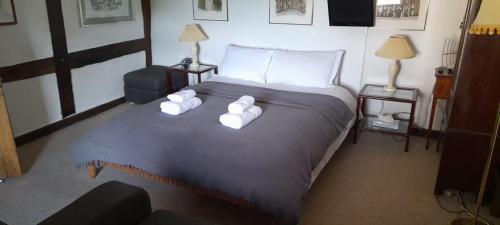 a bedroom with a large bed with white towels on it at The Old Court House Guest House in Ross on Wye