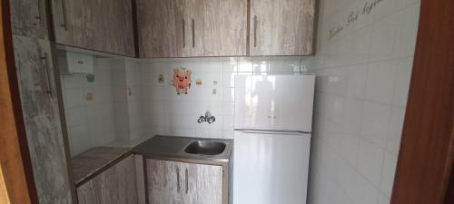 a small kitchen with a white refrigerator and cabinets at VISTAS PLAYA - Torre San Jordi in Alicante
