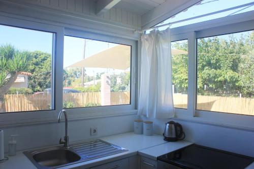 a kitchen with two windows and a sink at Brand new house with garden, next to the beach in Áyios Ilías