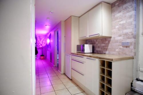 eine Küche mit violetten Lichtern in einem Zimmer in der Unterkunft The Bunkhouse in South Shields