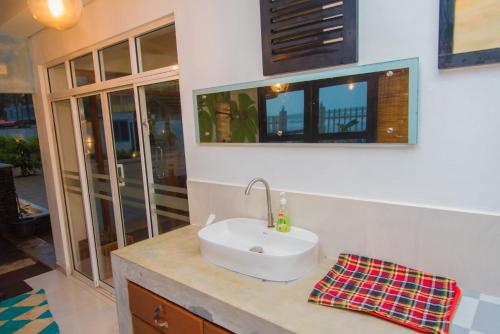 a bathroom with a white sink on a counter at Mahi Beach Hotel & Restaurant 