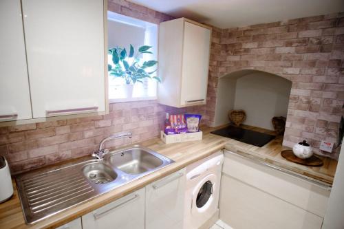 a kitchen with a sink and a washing machine at The Bunkhouse in South Shields