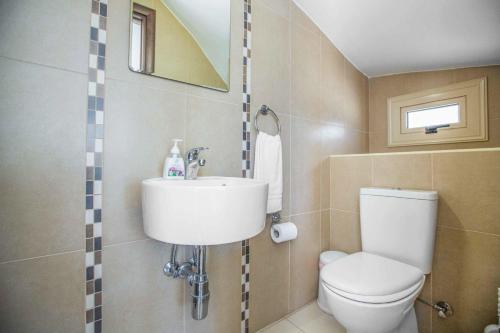 a bathroom with a toilet and a sink at Villa Delia in Protaras