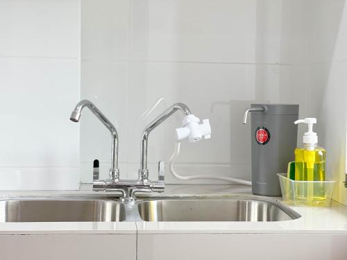 a kitchen sink with two faucets on top of it at MH Maison by Manhattan Group in Kuala Lumpur