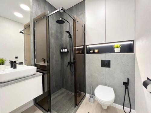 a bathroom with a shower and a toilet and a sink at Квартира Smart в новом доме in Pavlodar