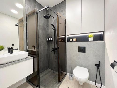y baño con ducha, aseo y lavamanos. en Квартира Smart в новом доме, en Pavlodar