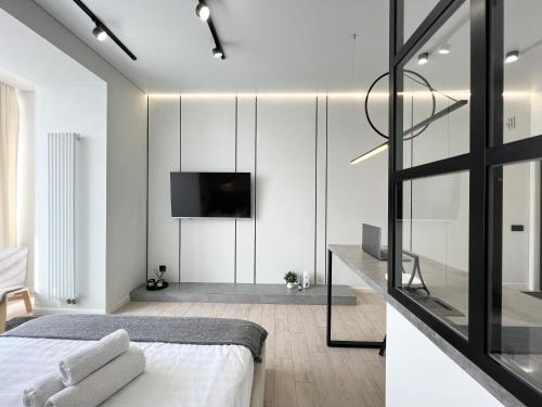 1 dormitorio con 1 cama y TV en la pared en Квартира Smart в новом доме, en Pavlodar